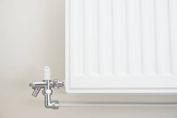 New white radiator white on pale wall house interior New white radiator white on pale wall house interior uk air valve photos stock pictures, royalty-free photos & images