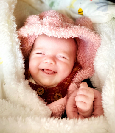 Six week old baby girl in fluffy blanket and winter clothing