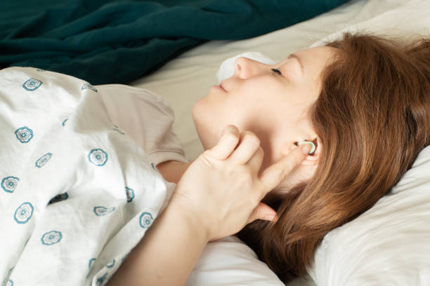 istock noise insert,woman puts a plug in her ear before going to bed so that the noise does not interfere with sleep 1384552479