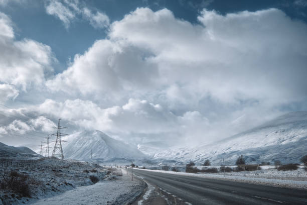 Winter road through Scottish Highlands and snowy mountains stock photo