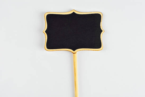 istock Isolated black wooden board for inscriptions on a white background. Product information panel. Price list or sign for product advertising. Free space for text and copy space on black board. 1384560375
