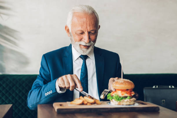 istock Senior businessman at restaurant table 1384561377