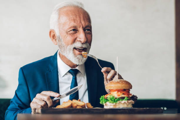 istock Senior businessman at restaurant table 1384561379