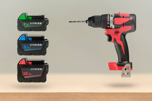 istock Batteries for cordless tools. Batteries for a screwdriver of different capacities and different sizes. Electric drill and three batteries with a charge indicator on a wooden background 1384567879