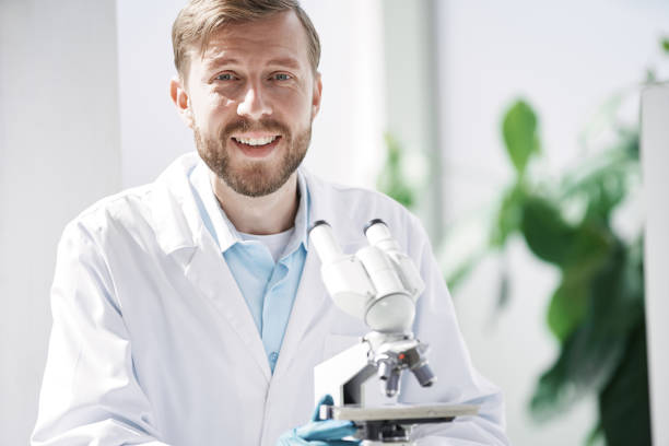 istock smiling scientist sitting at a laboratory table 1384570215
