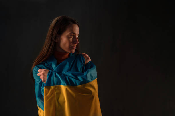istock Sad woman covered with Ukraine flag 1384576935
