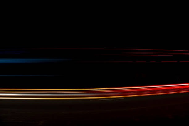Red and white lights from passing cars. Night highway.
