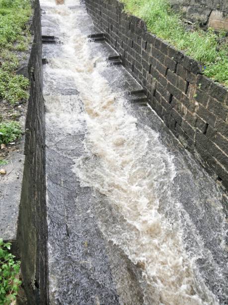 istock Rain water gushing with force down drains made of paved stones 1384581147