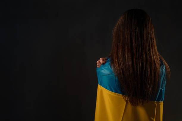 istock Sad woman covered with Ukraine flag 1384581355