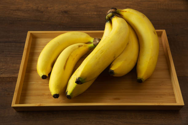 istock Bananas on wooden background 1384581365
