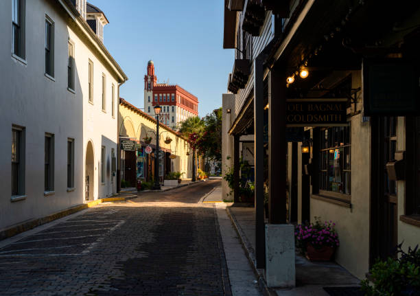 Historic narrow Aviles Street in the Downtown Saint Augustine, Florida is deserted and quiet in the early morning before tourists come. Historic narrow Aviles Street in the Downtown Saint Augustine, Florida is deserted and quiet in the early morning before tourists come. st george street stock pictures, royalty-free photos & images