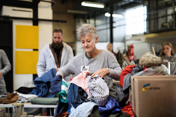 volontari che smistano i vestiti donati per i bisogni dei migranti ucraini, concetto di aiuto umanitario. - charity and relief work immagine foto e immagini stock