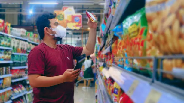 a man wearing a mask is shopping at a convenience store