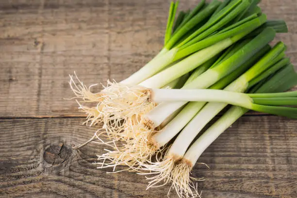 Fresh spring onions on the wooden table