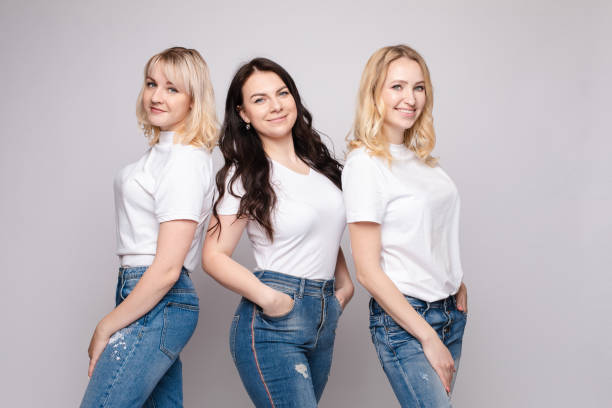 istock Three beautiful women in white shirts and jeans posing 1384596587