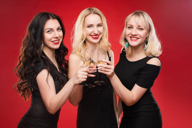 Three female friends celebrating a party event having fun and smiling with balloons