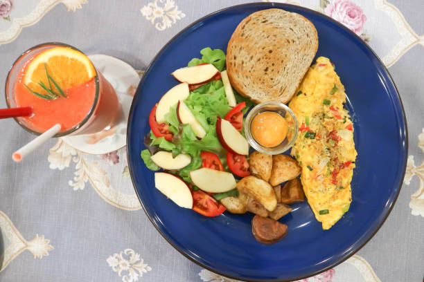 omelette , omelet or scrambled egg with salad and fried potato and strawberry smoothie stock photo
