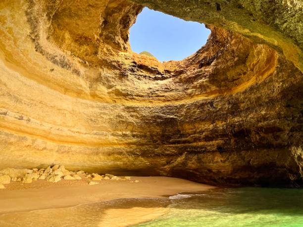 istock Benagil cave rock hole formations cliffs beach beach sand water 1384602406