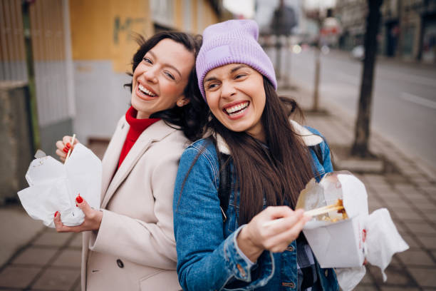istock Girlfriends laugh and eat Chinese food 1384604009