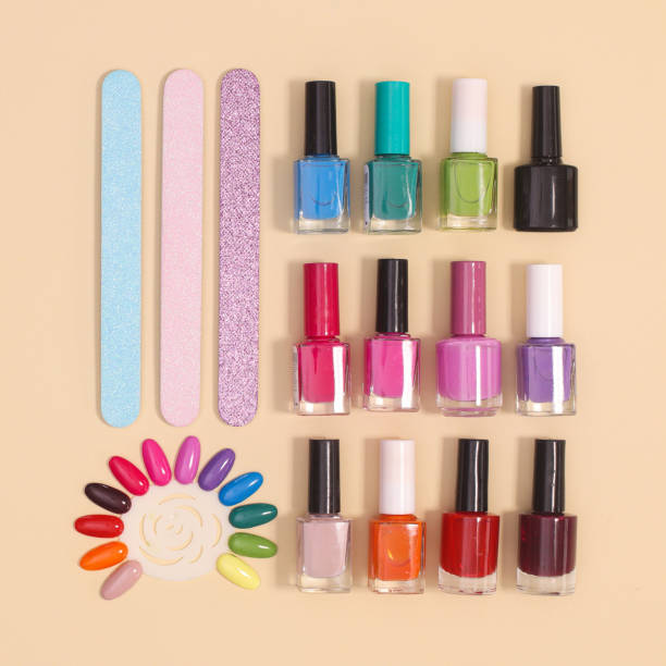 istock Creative layout with manicure set  and nail polish bottles in various colors on pastel beige background. Flat lay 1384604377