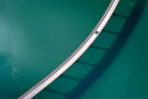 Aerial view of green car over bridge