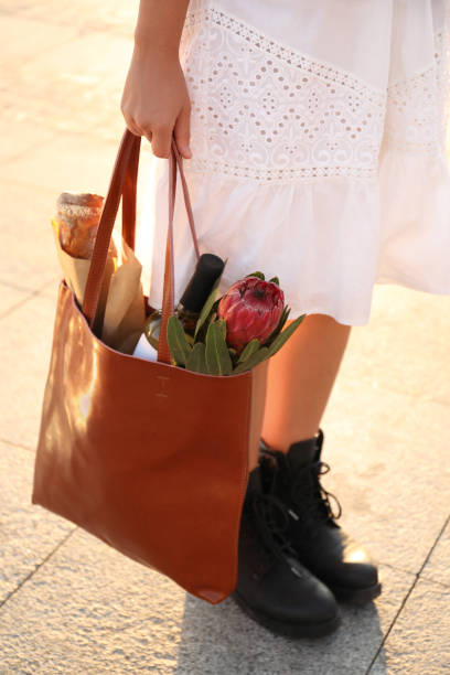 istock Woman with leather shopper bag outdoors, closeup 1384608164