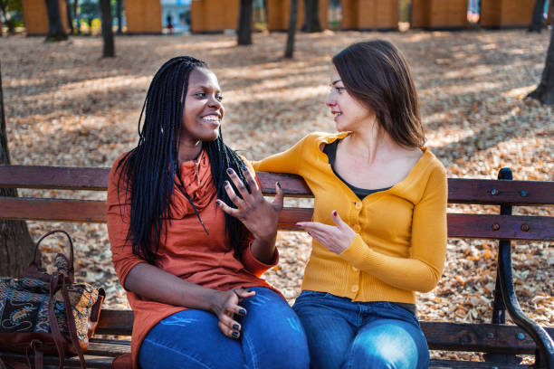 Multiethnic friends sitting on a park bench catching up