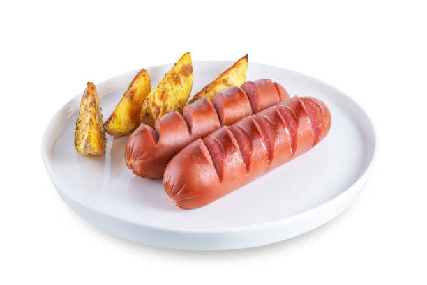 Fried sausages with roasted potatoes in a plate on a white isolated background. tinting. selective focus