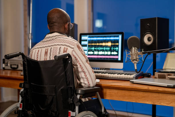 istock Rear view of man with disability using sound recording program in studio 1384610410