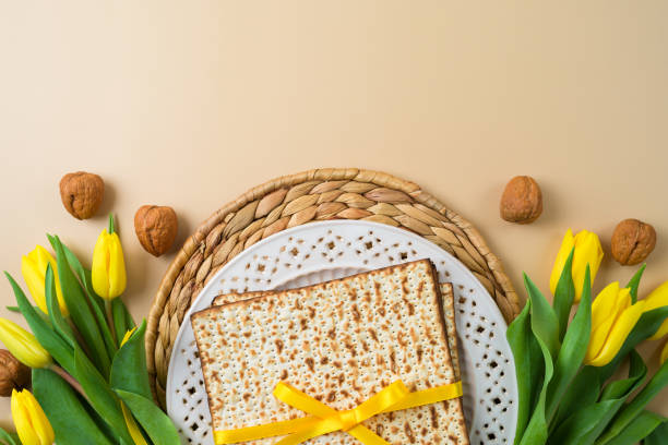 concetto di pasqua ebraica con matzah, piatto seder e fiori gialli di tulipano su sfondo moderno - matzo passover seder judaism foto e immagini stock