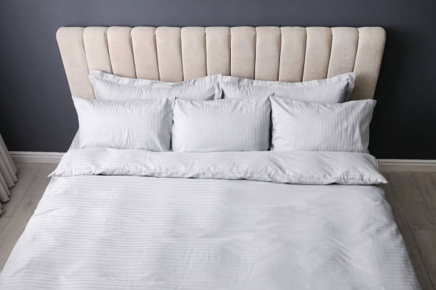 istock Comfortable bed with soft blanket and pillows indoors 1384611796