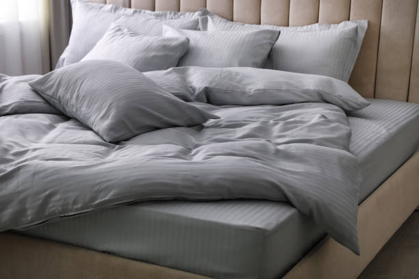 istock Comfortable bed with soft blanket and pillows indoors 1384611799