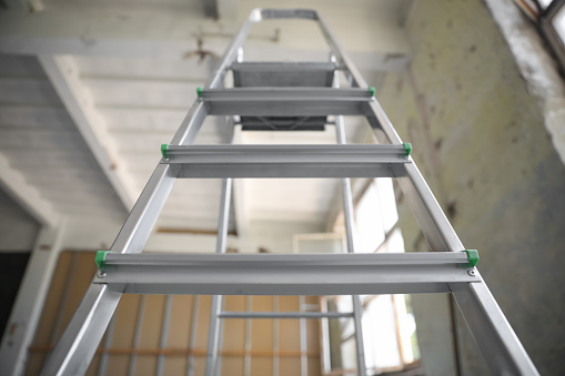 Metal ladder in old empty building, low angle view