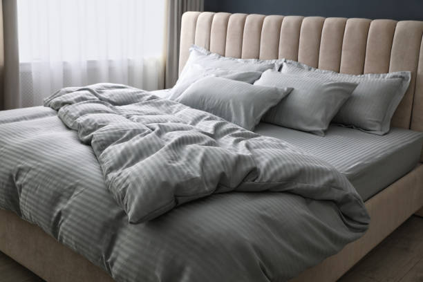 istock Comfortable bed with soft blanket and pillows indoors 1384611834