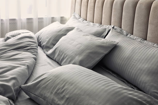 istock Comfortable bed with soft blanket and pillows indoors, closeup 1384611853