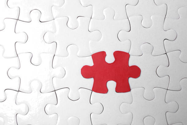 istock White jigsaw puzzles and red one as background, top view 1384611964