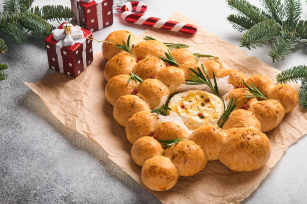 Bread buns Christmas tree with Roasted camembert cheese and rosemary on rustic background. Holiday recipes. Christmas menu. Christmas or Xmas pastries. Top view. Copy Space. stock photo