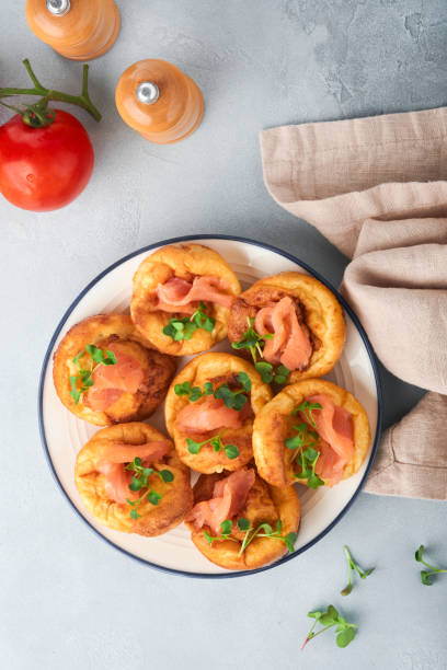 istock Yorkshire pudding. Traditional English Yorkshire pudding with salmon and radish microgreens side dish on white plate and light grey background table. Top view. 1384613325