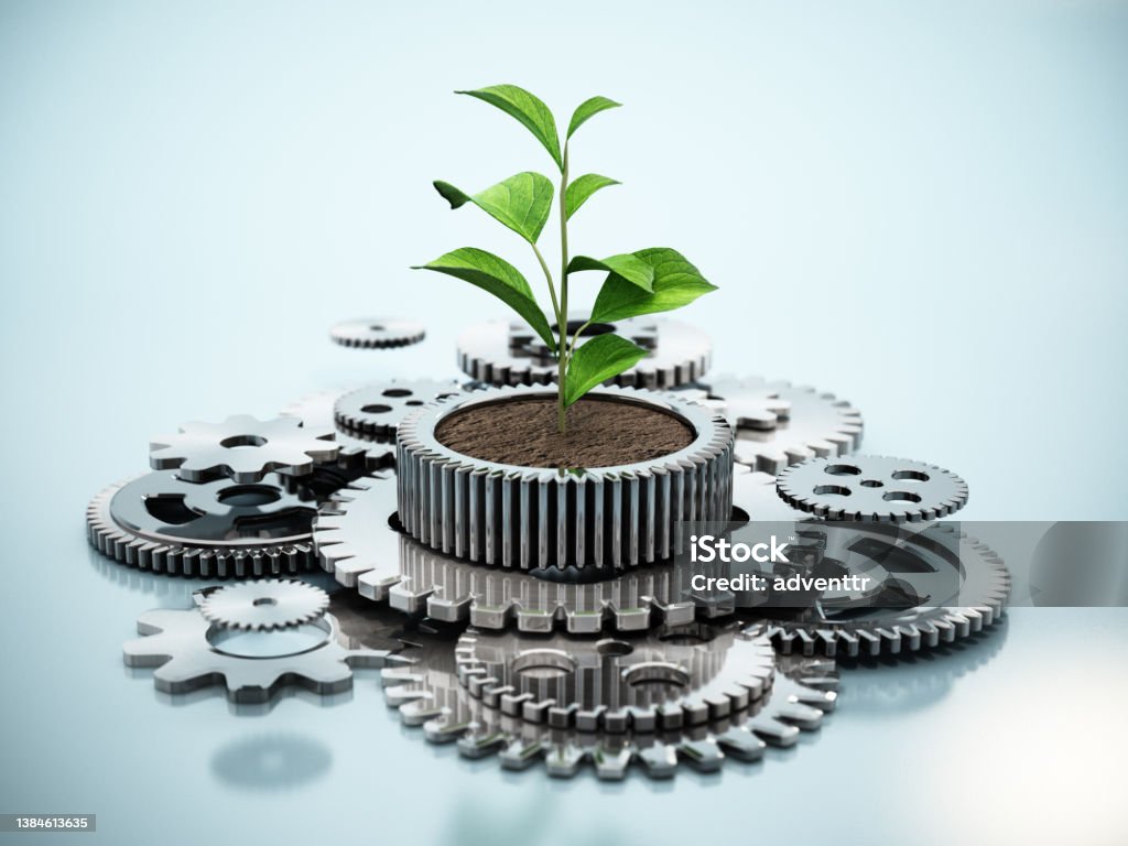 Plant growing inside the flower pot shaped cogwheel in motion. Sustainable industrial growth concept. Sustainable Lifestyle Stock Photo
