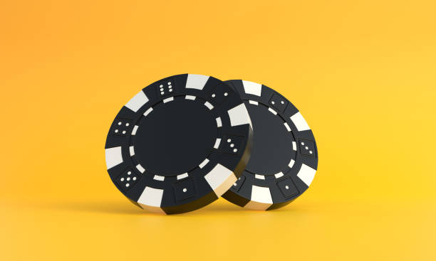 istock Black poker chips on a yellow background with copy space 1384613727