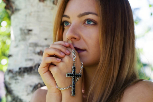 istock Religious young woman praying 1384613733