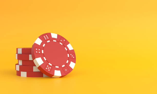 Red poker chips on a yellow background with copy space