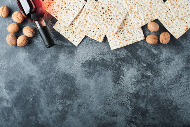 концепция празднования песаха. маца, красный кошерный и грецкий орех. традиционный ритуальный еврейский хлеб на старом темно-сером бетонно - passover matzo wine wine bottle стоковые фото и изображения