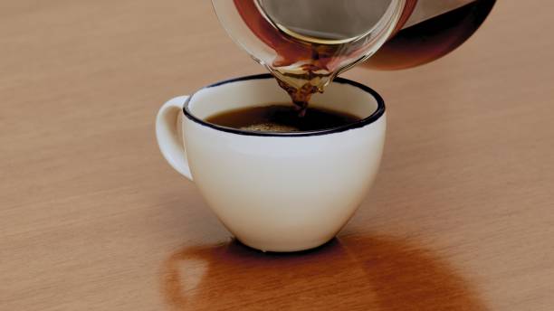 istock Black specialty coffee being served in mug on wooden table 1384620571