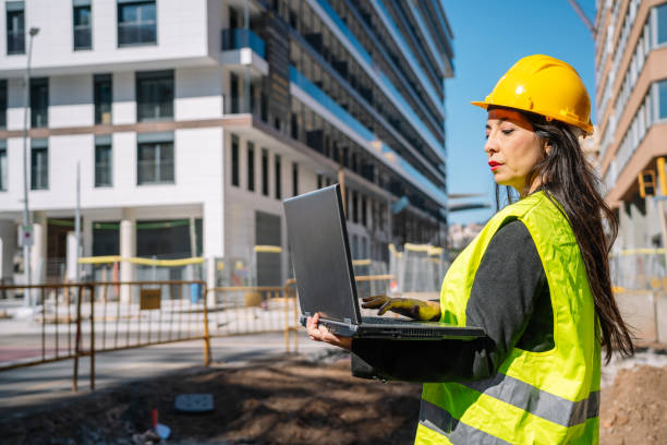 istock Busy Hispanic female inspector using laptop at construction site 1384623957