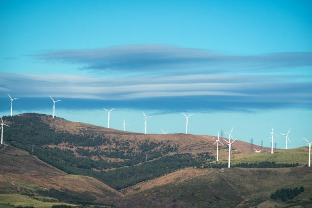 Lenticular clouds over the wind turbines of a wind farm stock photo