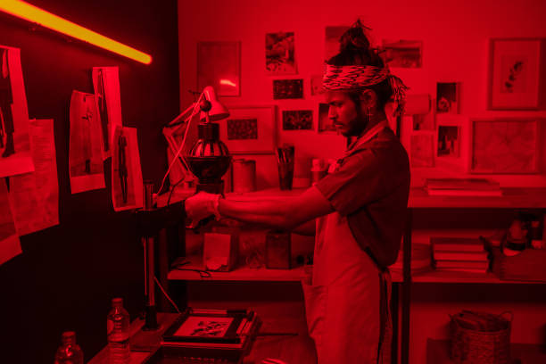 istock Young serious photographer using photo enlarger during work in laboratory 1384626243