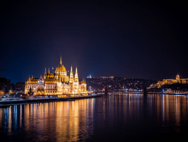 parlamento di budapest di notte con danubio e luci della città - royal palace of buda immagine foto e immagini stock