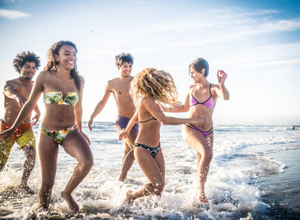 istock Friends running on the beach 1384627603