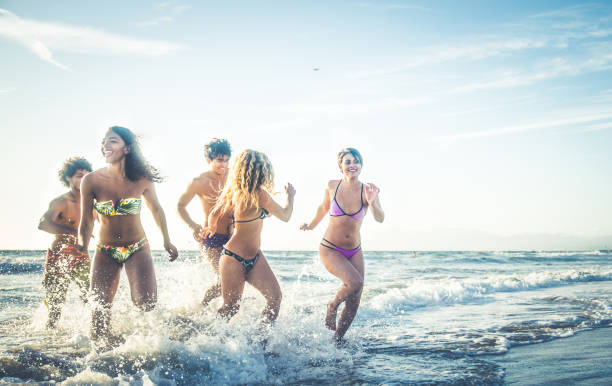 istock Friends running on the beach 1384629012